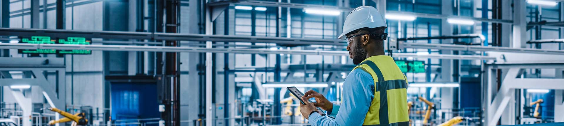 Arbeiter mit Tablet steht in der Produktion