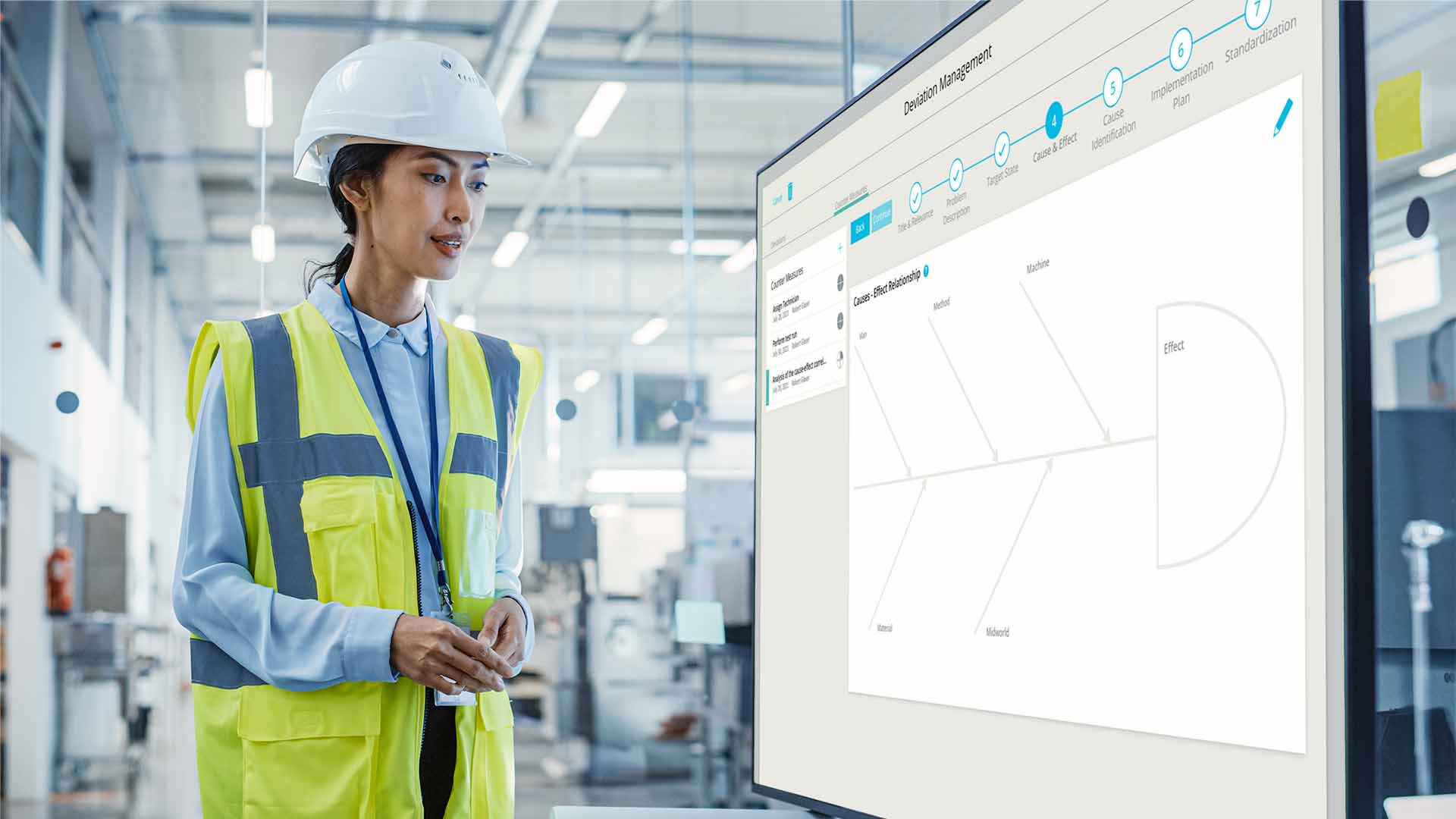 Woman looks at Ishikawa diagram on digital Shop Floor Board